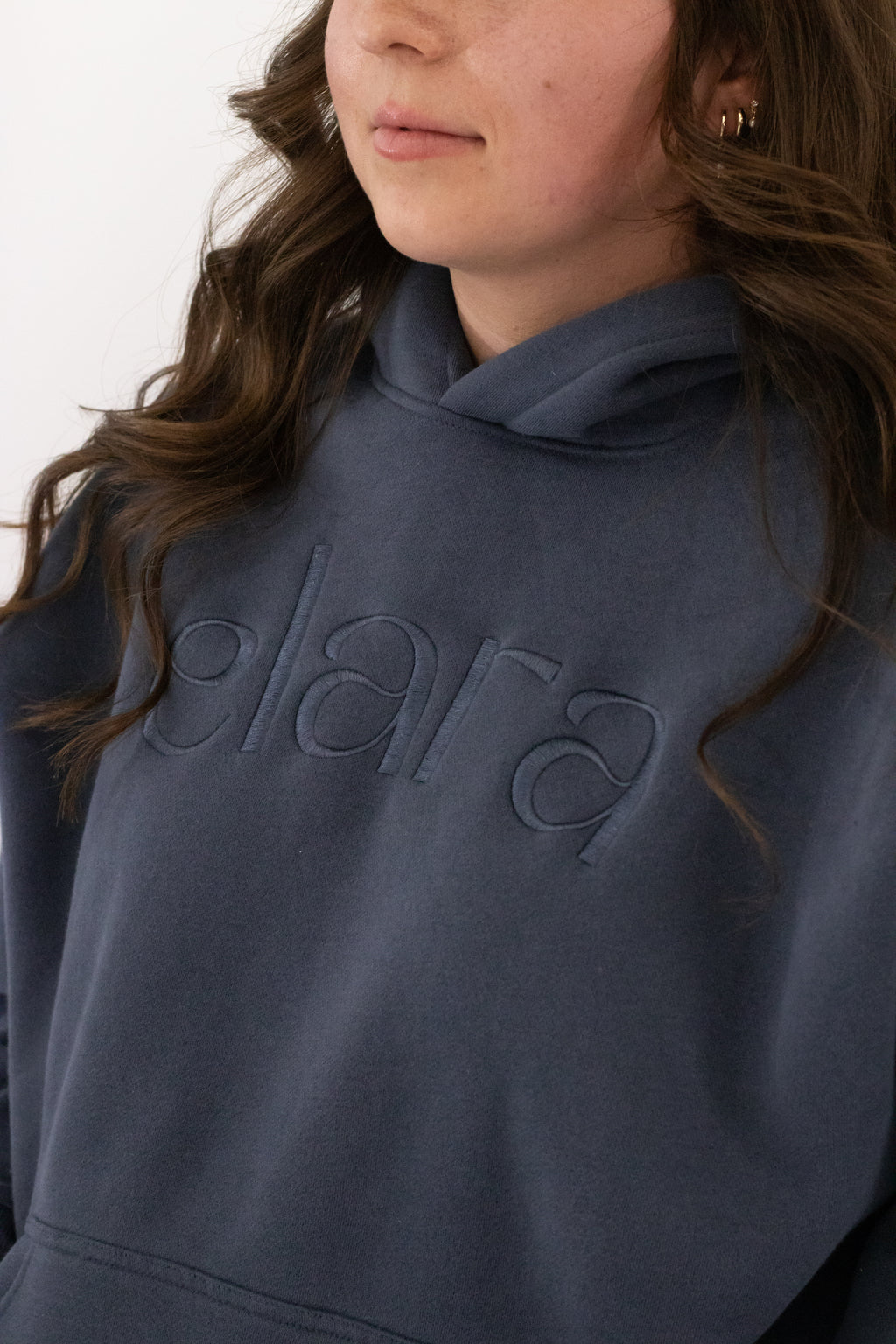 Person wearing a blue hoodie with 'elara' branding